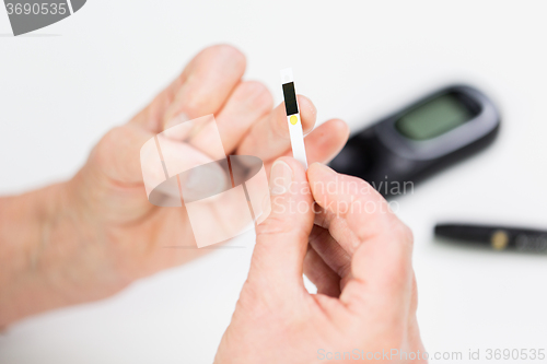 Image of senior woman with glucometer checking blood sugar