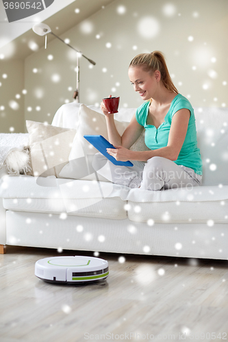 Image of happy woman with tablet pc drinking tea at home