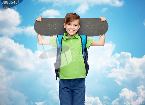 Image of happy student boy with backpack and skateboard