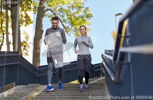 Image of happy couple running downstairs in city