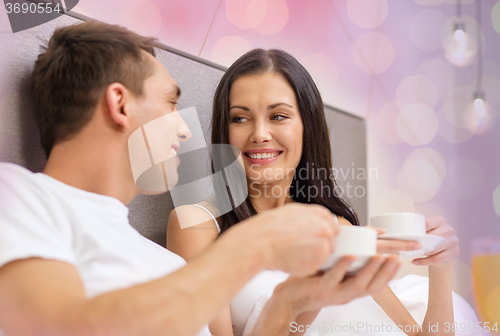 Image of happy couple drinking coffee in bed