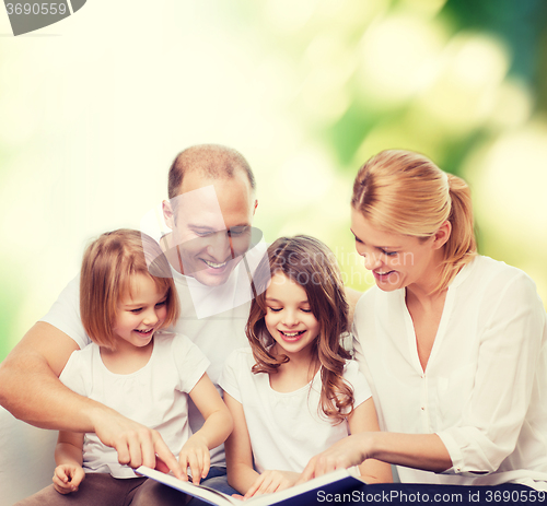 Image of happy family with book at home
