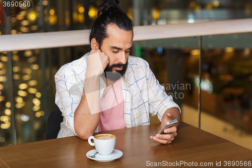 Image of man with smartphone and coffee at restaurant