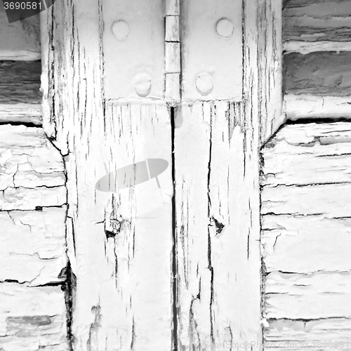 Image of in the old wall a hinged window green wood and rusty metal