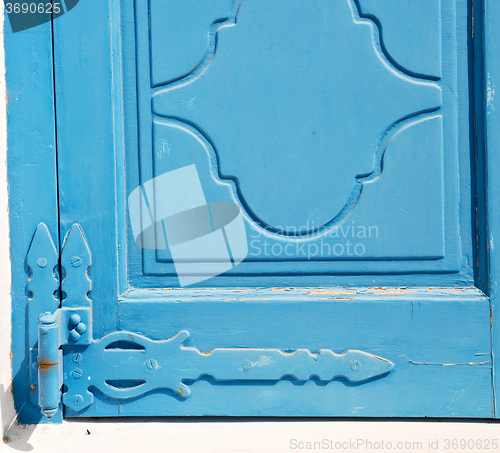 Image of in the old wall a hinged window blue wood and rusty metal