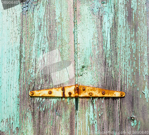 Image of in the old wall a hinged window green wood and rusty metal