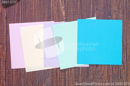 Image of color paper on wooden background