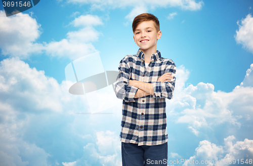 Image of smiling boy in checkered shirt over blue sky