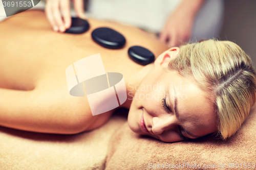 Image of close up of woman having hot stone massage in spa