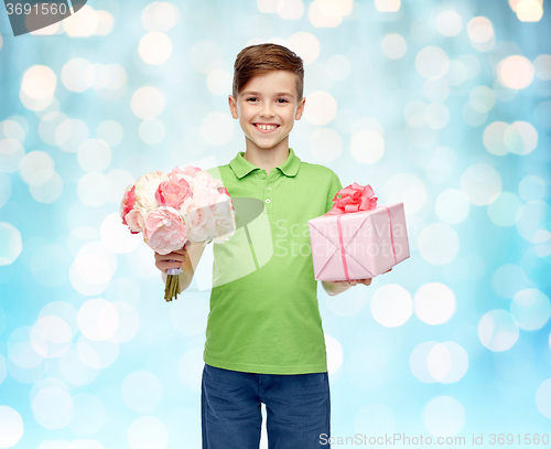 Image of happy boy holding flower bunch and gift box