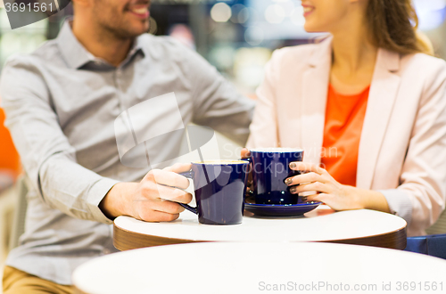 Image of close up of happy couple drinking coffee in mall