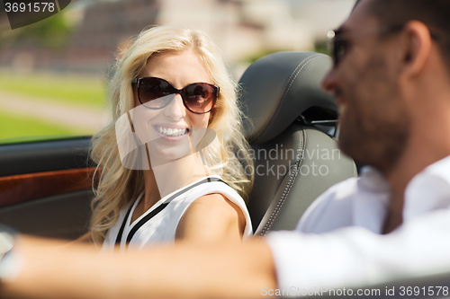 Image of happy man and woman driving in cabriolet car