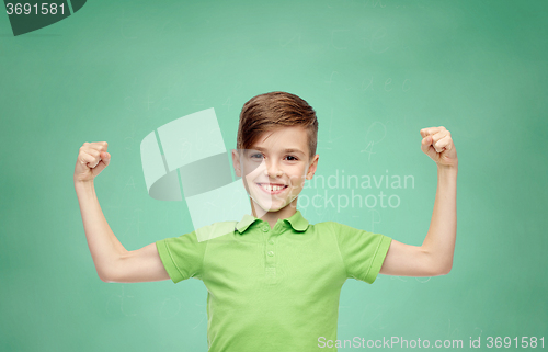 Image of happy boy in polo t-shirt showing strong fists