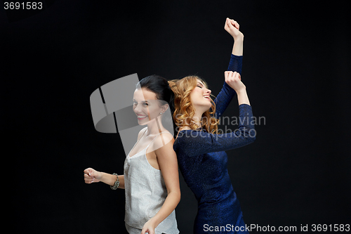 Image of happy young women dancing at night club disco