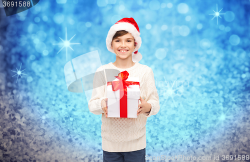 Image of smiling happy boy in santa hat with gift box