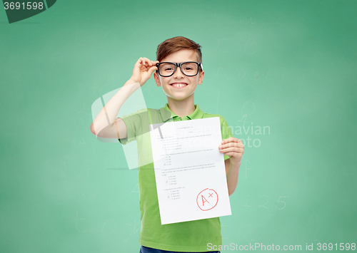 Image of happy boy in eyeglasses holding school test result