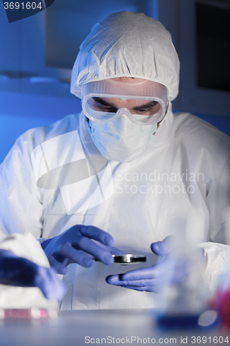 Image of close up of male scientist with test sample in lab