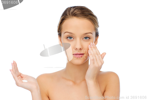 Image of young woman applying cream to her face