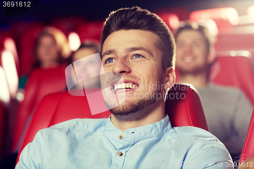 Image of happy young man watching movie in theater