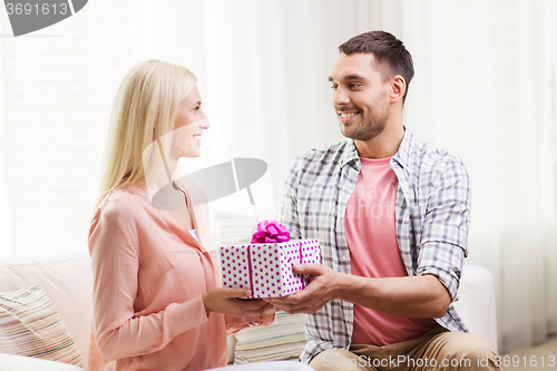 Image of happy man giving woman gift box at home