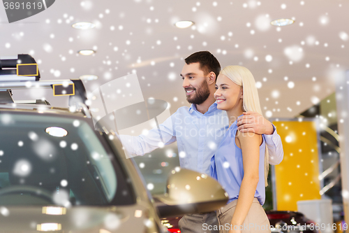 Image of happy couple buying car in auto show or salon