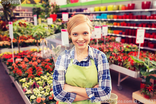 Image of happy woman with flowers in greenhouse