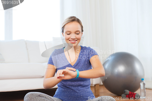 Image of happy woman with heart-rate watch exercising