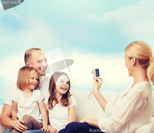 Image of happy family with camera at home