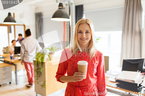Image of happy creative woman with coffee cup at office