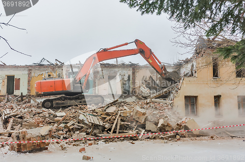 Image of Demolition of a house with an orange digger