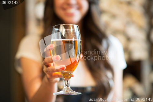 Image of happy woman holding glass of draft lager beer