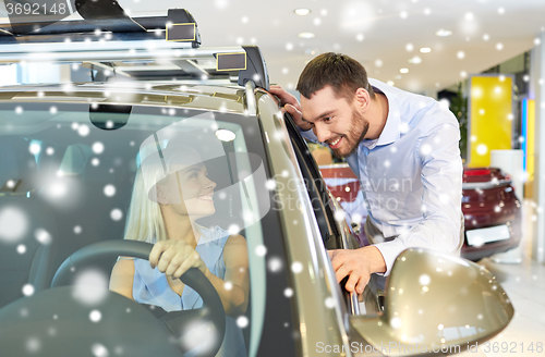 Image of happy couple buying car in auto show or salon