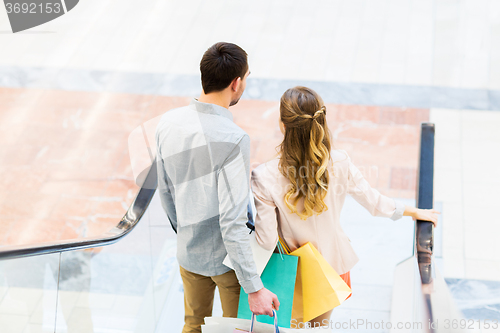 Image of happy young couple with shopping bags in mall