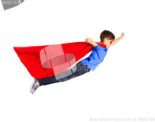 Image of boy in red superhero cape and mask flying on air