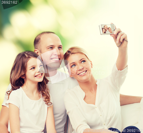 Image of happy family with camera at home