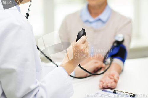 Image of doctor with tonometer and senior woman at hospital