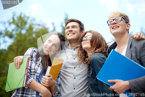 Image of group of happy students with folders outdoors