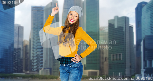 Image of happy young woman or teen girl pointing finger up