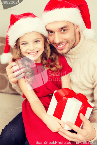 Image of smiling father and daughter holding gift box