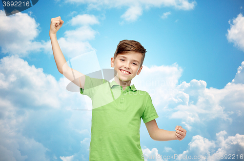 Image of happy boy in polo t-shirt showing strong fists