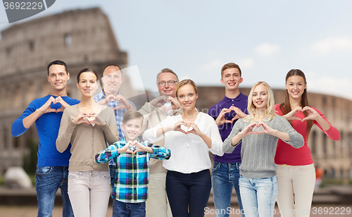 Image of happy people showing heart hand sign over coliseum