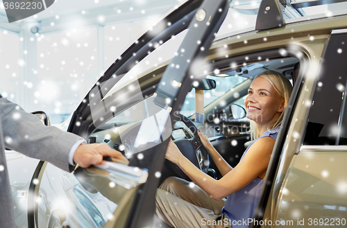 Image of happy woman with car dealer in auto show or salon