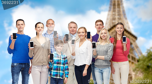 Image of group of people with smartphones over eiffel tower