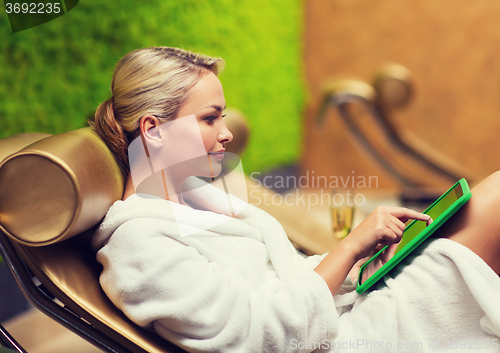 Image of beautiful young woman with smartphone at spa