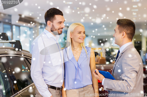 Image of happy couple with car dealer in auto show or salon