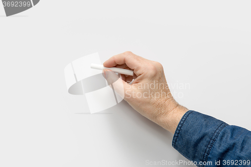 Image of hand with white crayon