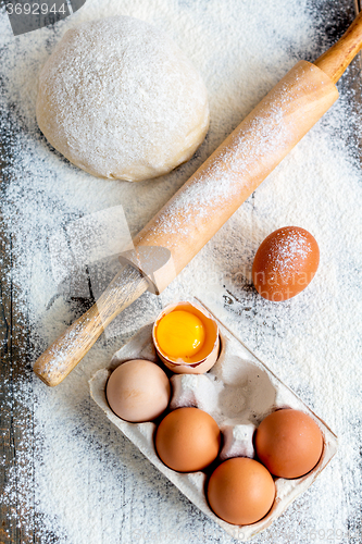 Image of Dough, rolling pin and a tray of eggs.