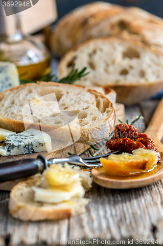 Image of Rural lunch with bread, cheese and sun-dried tomatoes.