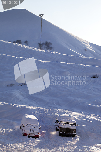 Image of Snow-covered cars with smiley in windshield