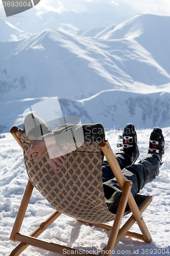 Image of Skier at winter mountains resting on sun-lounger